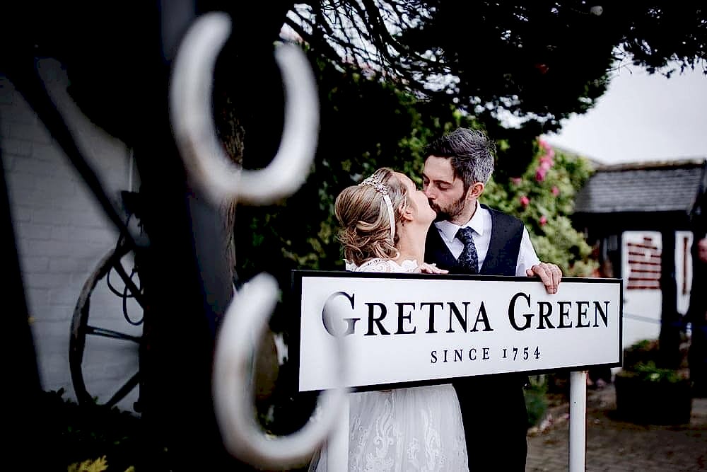 Wedding photo in front of the Gretna Green Since 1754 famous sign