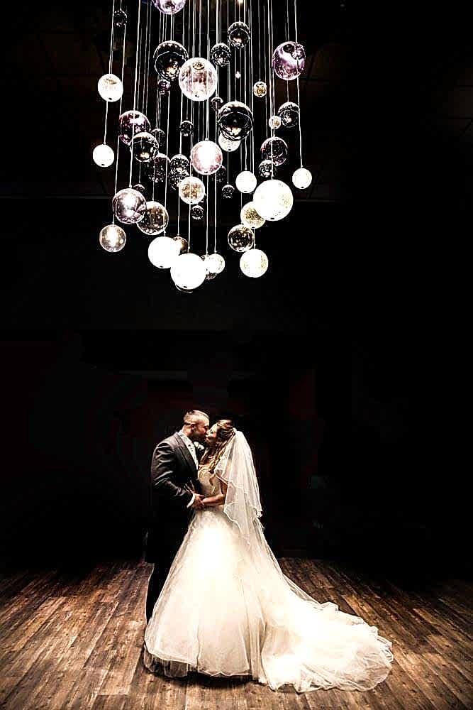 Wedding photo under the chandelier in Greens Hotel atrium