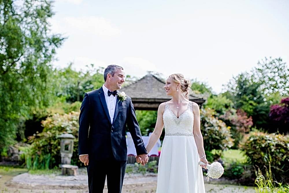 Wedding photo in front of the wedding pergola in the Water Gardens at Greens hotel, Gretna